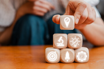 Wooden blocks with icons representing strategic planning, innovation, and success in business. Ideal for illustrating growth concepts.