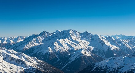 Fototapeta premium Majestic mountain range with snow-capped peaks and clear blue sky