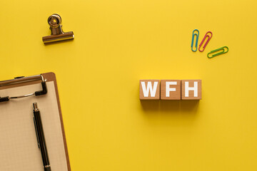 There is wood cube with the word WFH. It is an abbreviation for Work From Home as eye-catching...