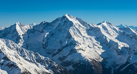 Obraz premium Majestic mountain range with snow-capped peaks and clear blue sky