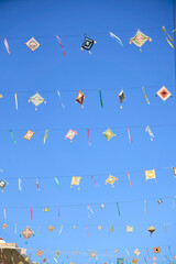 God's eyes or Ojos de Dios hanging over a street against a bright blue sky