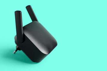 Black WiFi repeater on turquoise background