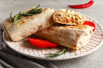 Plate with tasty shawarma and slices of bell pepper on grey table