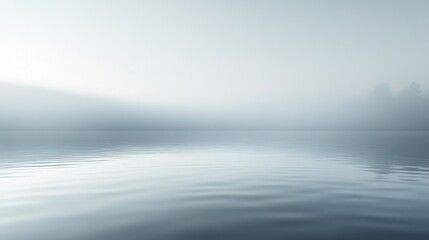 Obraz premium Serene Misty Lake at Dawn with Rippling Water and Soft Fog Surrounding Tranquil Landscape
