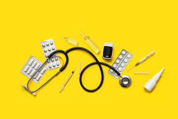 Composition with pulse oximeter, stethoscope and medicines on yellow background