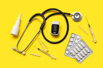 Composition with pulse oximeter, stethoscope and medicines on yellow background