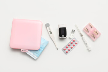 Fototapeta premium Pulse oximeter, thermometer, syringe, pill box and blister pack of pills on white background
