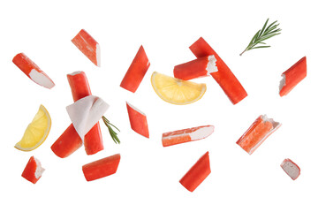 Tasty crab sticks with rosemary and slices of lemon flying on white background © Pixel-Shot