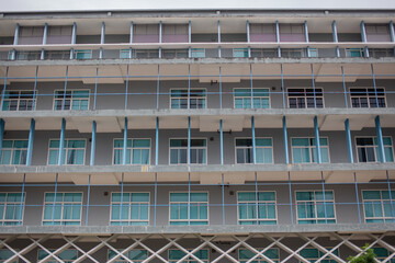 A building with four-story glass windows painted in gray.