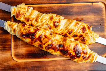 Kebabs cooking over wood fire in traditional outdoor kitchen