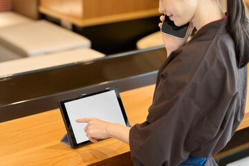 タブレットで管理をする飲食店の従業員
