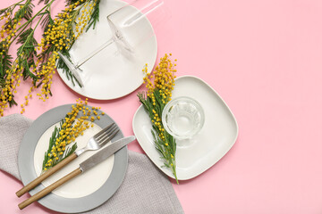 Beautiful table setting with mimosa flowers on pink background