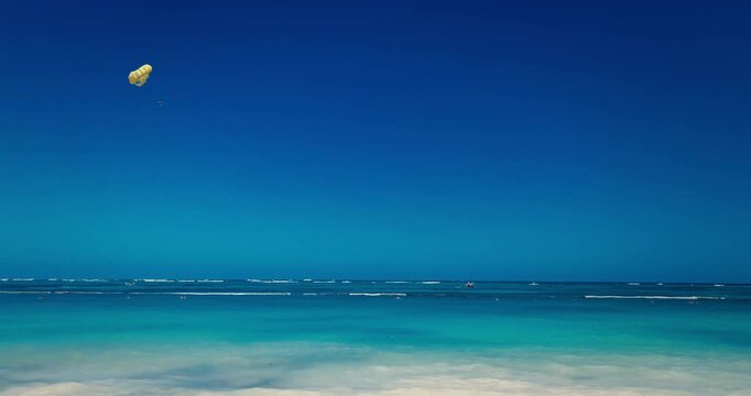 Parasailing on tropical caribbean sea. Water sport fun activities on summer vacation in Dominican republic