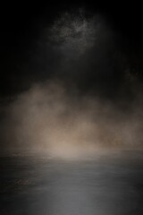 Charcoal black background with fine-grain texture and diffused golden stage light
