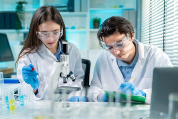 Asian male and female scientists work together in the research laboratory.