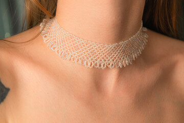 JUNE 23, 2024, QINGDAO, CHINA: White pearl colored ornate necklace made of beads on a neck of unidentified model, ethnic jewelry