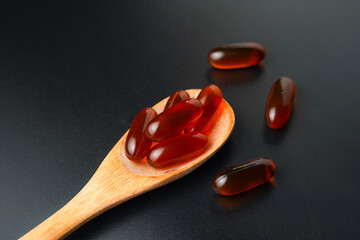 Vitamin capsules in a wooden spoon, soft gels, Fish oil capsules, omega 3, omega 9, vitamin D,...