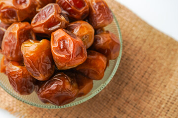 Dates fruit sukari or kurma sukari, in bowl isolated on white background