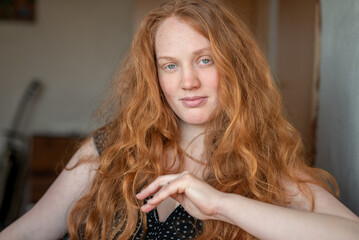 A natural and expressive close-up portrait of a woman with red hair and green eyes radiating...