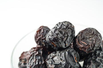 Dates fruit ajwa or kurma ajwa, in bowl isolated on white background