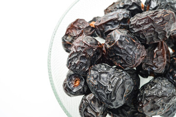 Dates fruit ajwa or kurma ajwa, in bowl isolated on white background