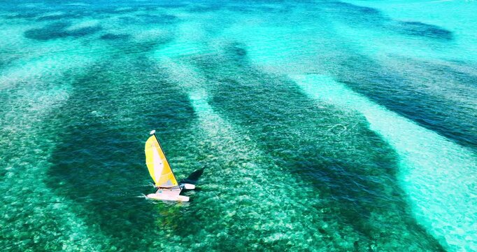 Sailboat catamaran sailing on clear turquoise reef waters of caribbean sea, water sports activities during summer tropical vation in Dominican republic