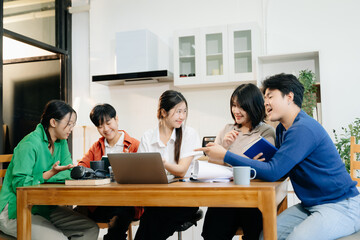 Teamwork and creativity with young adults collaborating on laptops and tablets in a cozy