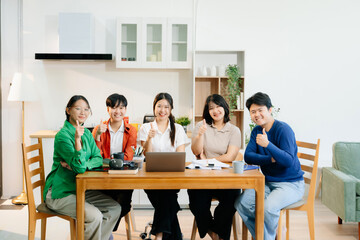 Teamwork and creativity with young adults collaborating on laptops and tablets in a cozy