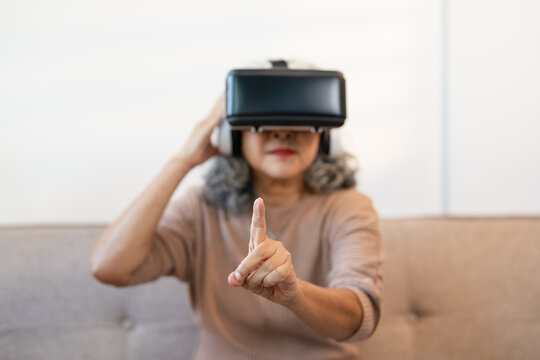 Senior mature woman having fun with virtual reality glasses - Old people using new headset goggles trends technology - Joyful elderly lifestyle concept