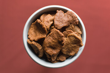 Overhead view of kuli-kuli in a white bowl, top view of nigerian groundnut cakes in a bowl