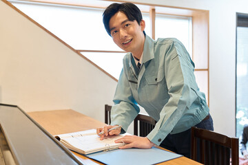 飲食店で図面を確認する男性