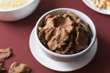 Overhead view of kuli-kuli in a white bowl, top view of nigerian groundnut cakes in a bowl