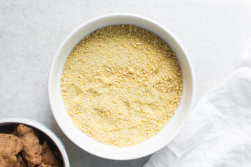 Overhead view of Yellow garri in a white bowl, top view of nigerian garri in a ceramic bowl, fried cassava, garri for eba
