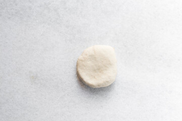 Overhead view of chinese scallion pancake dough on white countertop, top view of homemade scallion pancake dough, process of making cong you bing