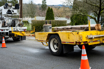 Residential power line maintenance and upgrade, heavy yellow trailer with old removed wood utility...