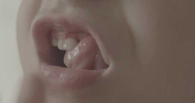 Child Wobbling Loose Tooth with Finger