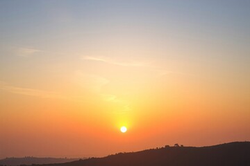 Obraz premium Beautiful sunset over hills with vibrant sky colors