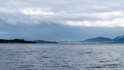 clouds over Strait of Georgia blue sky water landscape mountains on the horizon British Columbia Canada