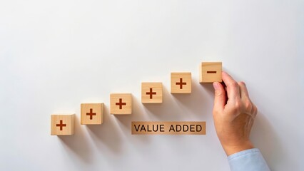 Hand Placing Block on Rising Stacks Symbolizing Value Addition in Business Strategy