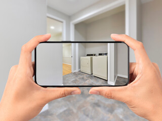 Person taking a photo of a modern residential laundry room with a cell phone