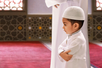 Indonesian asian muslim father and innocence son praying together in the mosque, eid adha mubarak concept