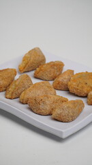 A plate of fried tahu walik is placed on a white base and background (isolated white).