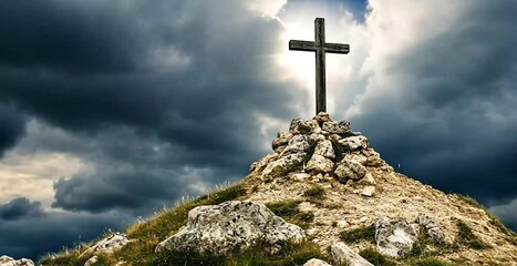 The cross stands atop a rocky hill, a symbol of faith against a dramatic, cloudy sky.