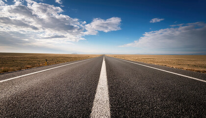 Fototapeta premium long open road stretching into distant horizon under vast blue sky