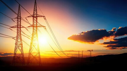 Fototapeta premium Electric Transmission Towers Against a Vibrant Sunset Sky with Dramatic Clouds and Warm Hues in a Serene Landscape
