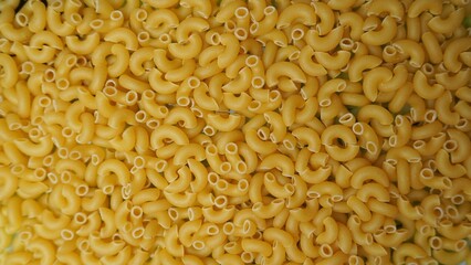 Macaroni horns close up.
Close-up of raw pasta cones. The texture of the pasta, the crumbled pasta, is yellow. Background for cooking and Italian cuisine.