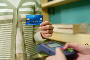 Customers pay with credit cards at fruit shop with small business owners. Close-up of blue credit...