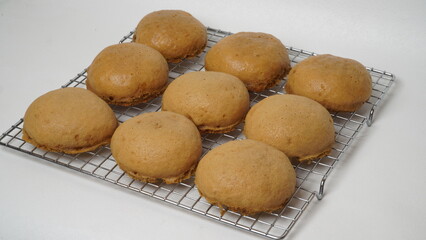 Coffee milk buns are served using a cooling rack that is placed on a white background (isolated white).