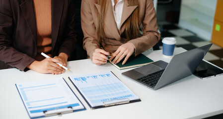 Business hand using laptop and tablet with social network diagram and two colleagues discussing data
