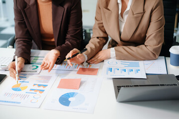 The business team analyzes revenue charts and graphs with laptop and tablet.Business analysis